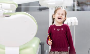 Little girl smiling while holding tooth brush.jpg
